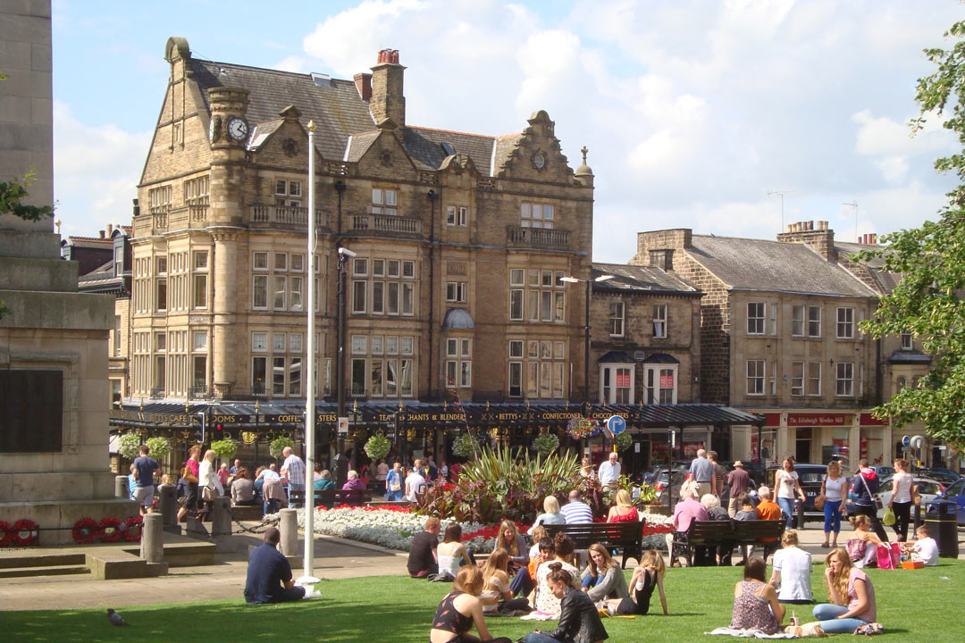 Harrogate town centre People lounging on the green grass in Harrogate's picturesque town centre next to the war memorial. In the background stands Betty's tea rooms.