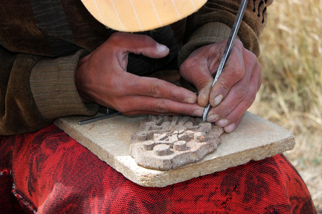 A local is crafting a model made of stone