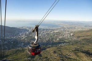 Cable car descending over the slopes of Table Mountain towards Cape Town below.