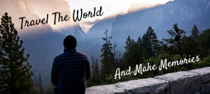A man sits on a wall looking out into the distant landscape of pine trees and dramatic mountains. Text reads "Travel the world and make memories"