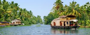A traditional houseboat cruises gently down the backwaters of Kerala