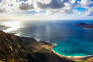 A view of the turquoise blue sea and dark volcanic landscape from the Mirador del Río view point