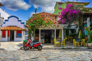 Cobbled Rua das Pedras in Búzios, lined with colourful cafés, tiled buildings and flowering bougainvillea