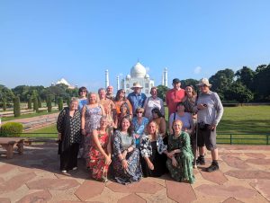 A Traveleyes group stand together in front of  the iconic white domed Taj Mahal