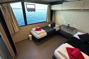 Twin cabin aboard Seagull with two single beds and a large window overlooking the Adriatic Sea