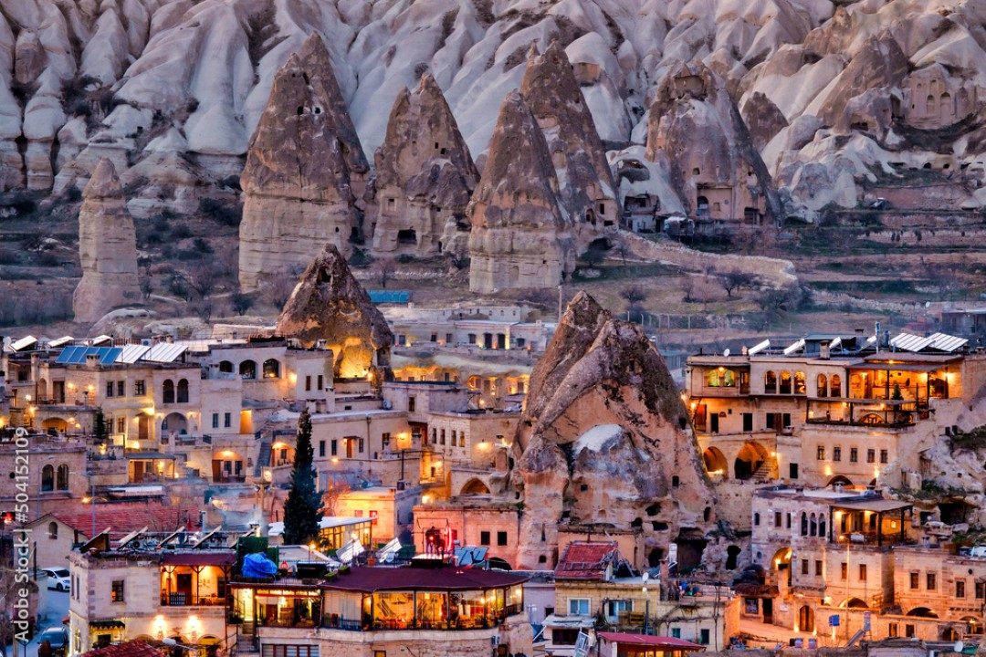 Fairy chimneys in Goreme Fairy chimneys and cave houses glowing at dusk, Cappadocia