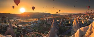 Hot air balloons floating above Cappadocia’s distinctive fairy chimneys and valleys at sunrise, Cappadocia