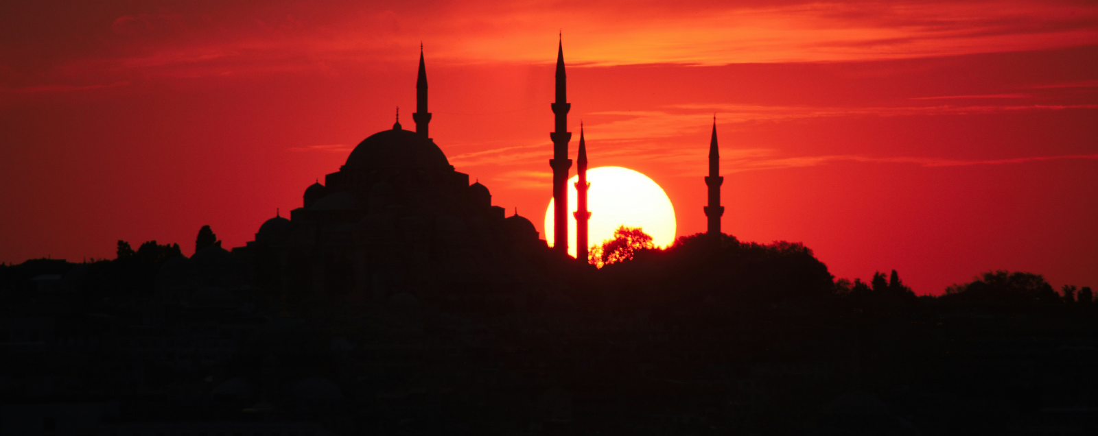 Silhouette of the minarets of the blue mosque again a deep red sunset