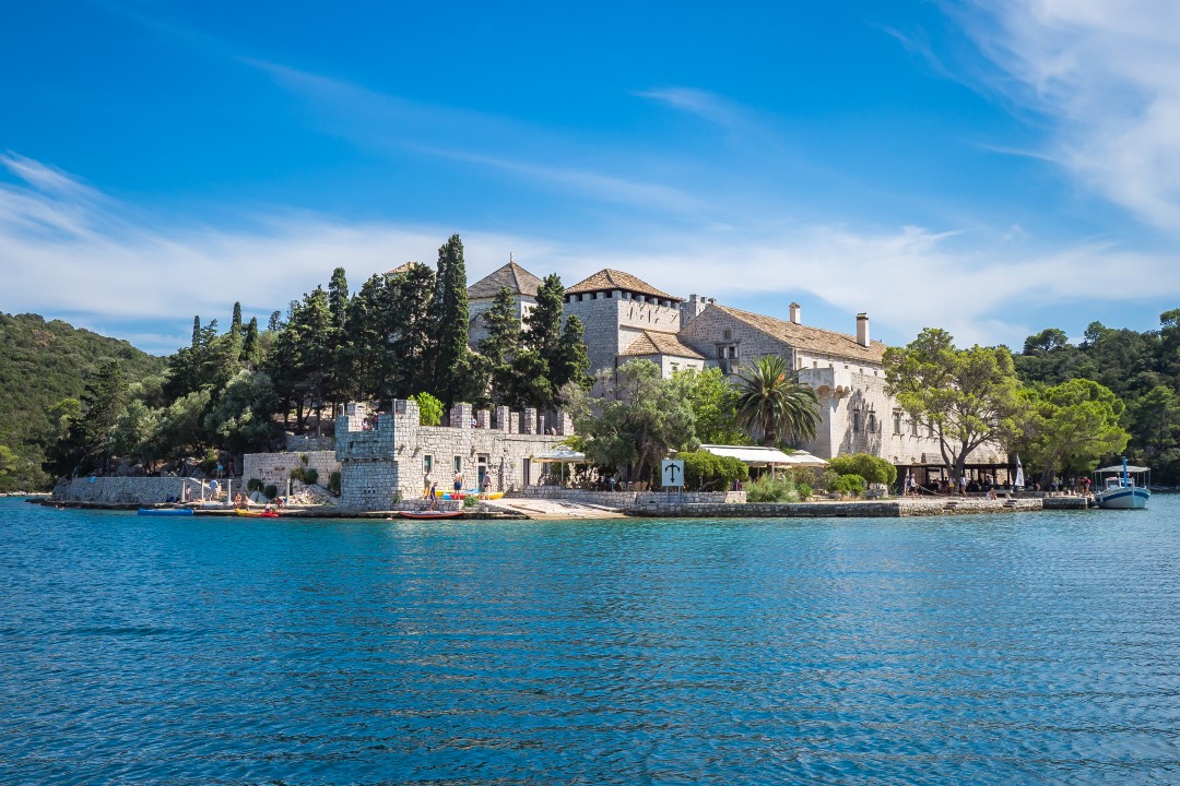 Benedictine monastery on St Mary’s Island surrounded by the calm blue waters and wooded landscape of Mljet National Park, Croatia