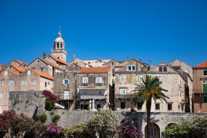 Historic stone houses, terracotta rooftops and a church bell tower in Korčula Old Town, Croatia