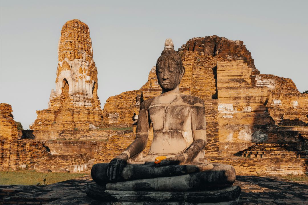 A stone buddha amongst temple ruins at Ayutthaya
